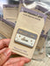 Lavender-and-cream name-tag enamel pin reading HELLO, I AM done, with metallic outlines and star accents.