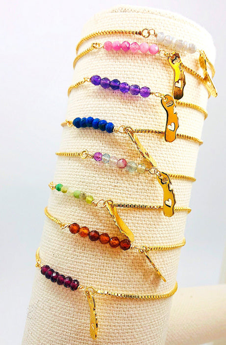 Cute charm bracelet with acrylic beads and metal pendants. Handmade beaded  bracelet. Fashion women's stylish accessory. Fashionable design craft. Hand  beautiful decoration. Lilac background Stock Photo | Adobe Stock